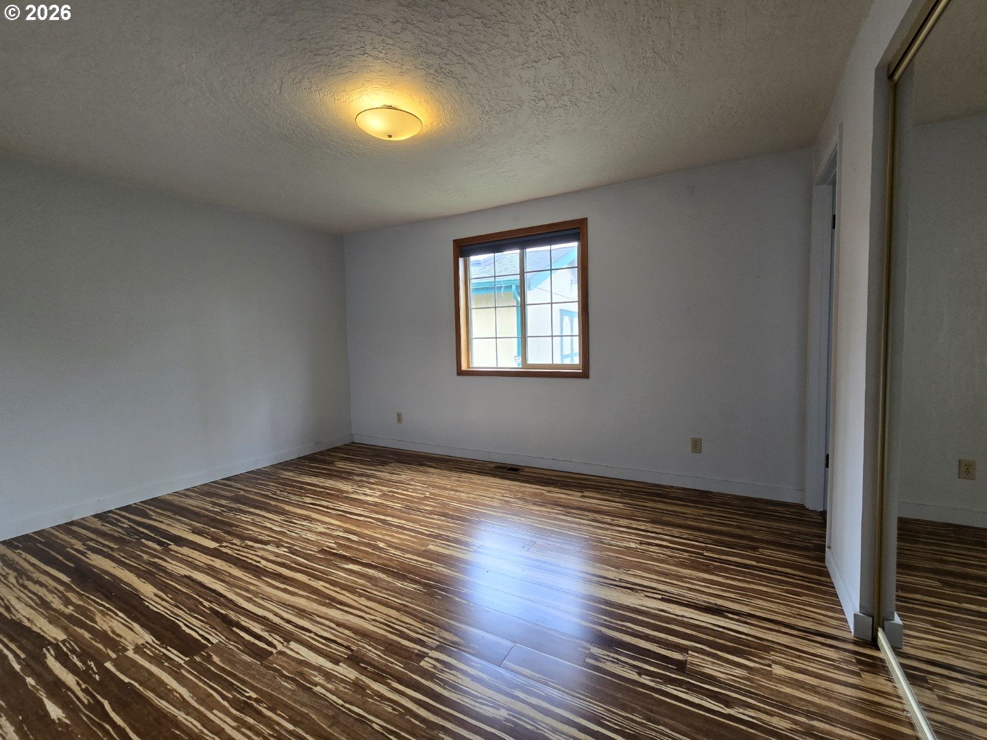 2633 42nd Avenue Longview, WA 98632 - Photo 19 of 32 a view of an empty room with wooden floor and a window