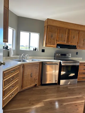 a kitchen with granite countertop a stove a sink and a microwave