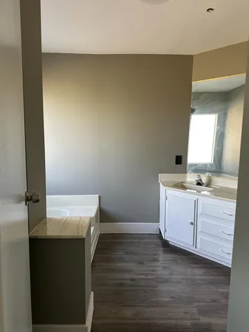 a room with a sink cabinets and wooden floor