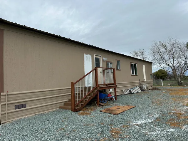 a backyard of a house with barbeque oven table and chairs