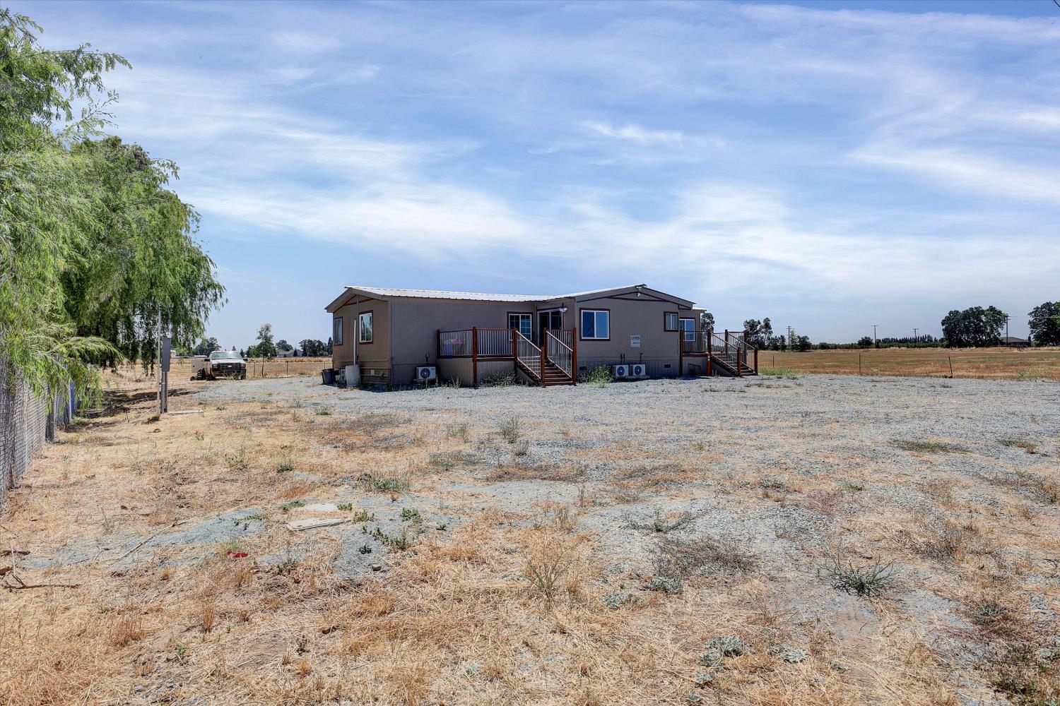 11705 Simmerhorn Road Galt, CA 95632 - Photo 22 of 39 a view of large house with a big yard and covered with trees