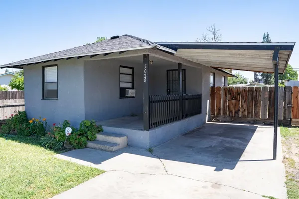 a view of a house with a wooden fence