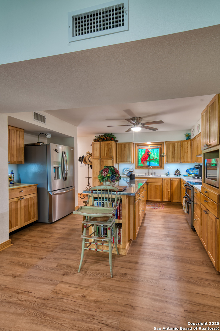 412 Field Road Fischer, TX 78623 - Photo 30 of 42 a kitchen with stainless steel appliances a stove a sink a refrigerator cabinets and living room view