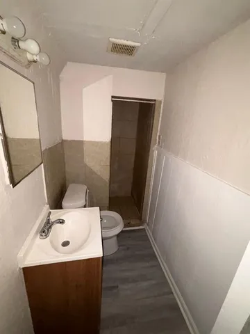 a bathroom with a sink a toilet and mirror