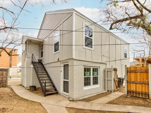 a view of a blue house with iron fence