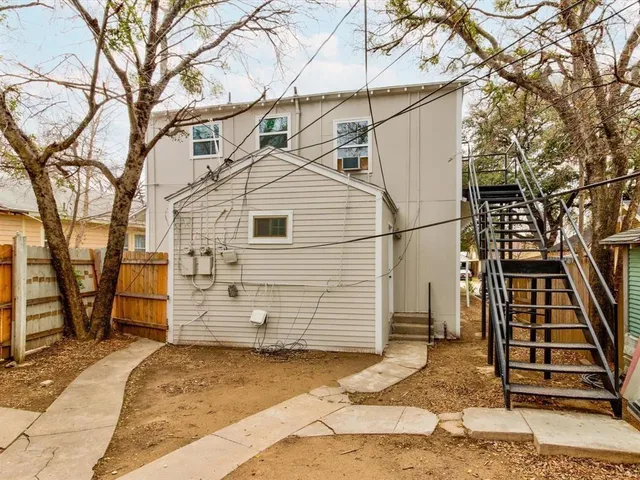 a view of a white house with a large tree