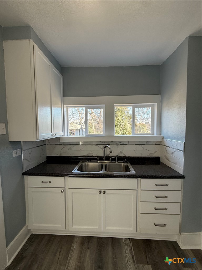 917 South 4th Street Temple, TX 76504 - Photo 13 of 30 a kitchen with granite countertop a sink and a white cabinets