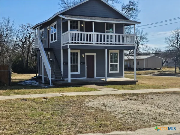 a view of a house with swimming pool next to a yard