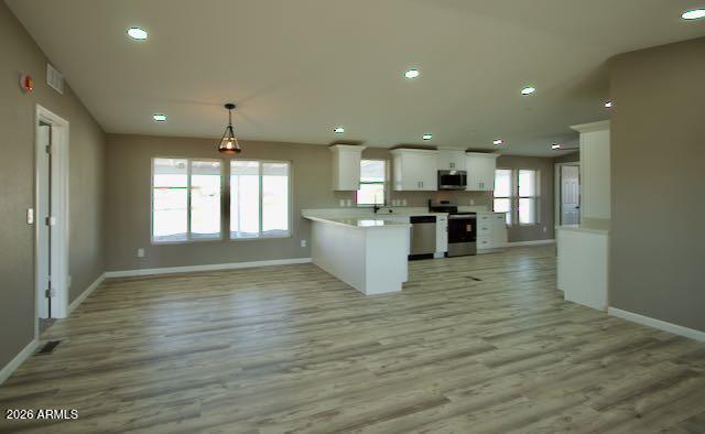 1470 South Bowman Road Apache Junction, AZ 85119 - Photo 19 of 56 a view of an empty room and kitchen with wooden floor