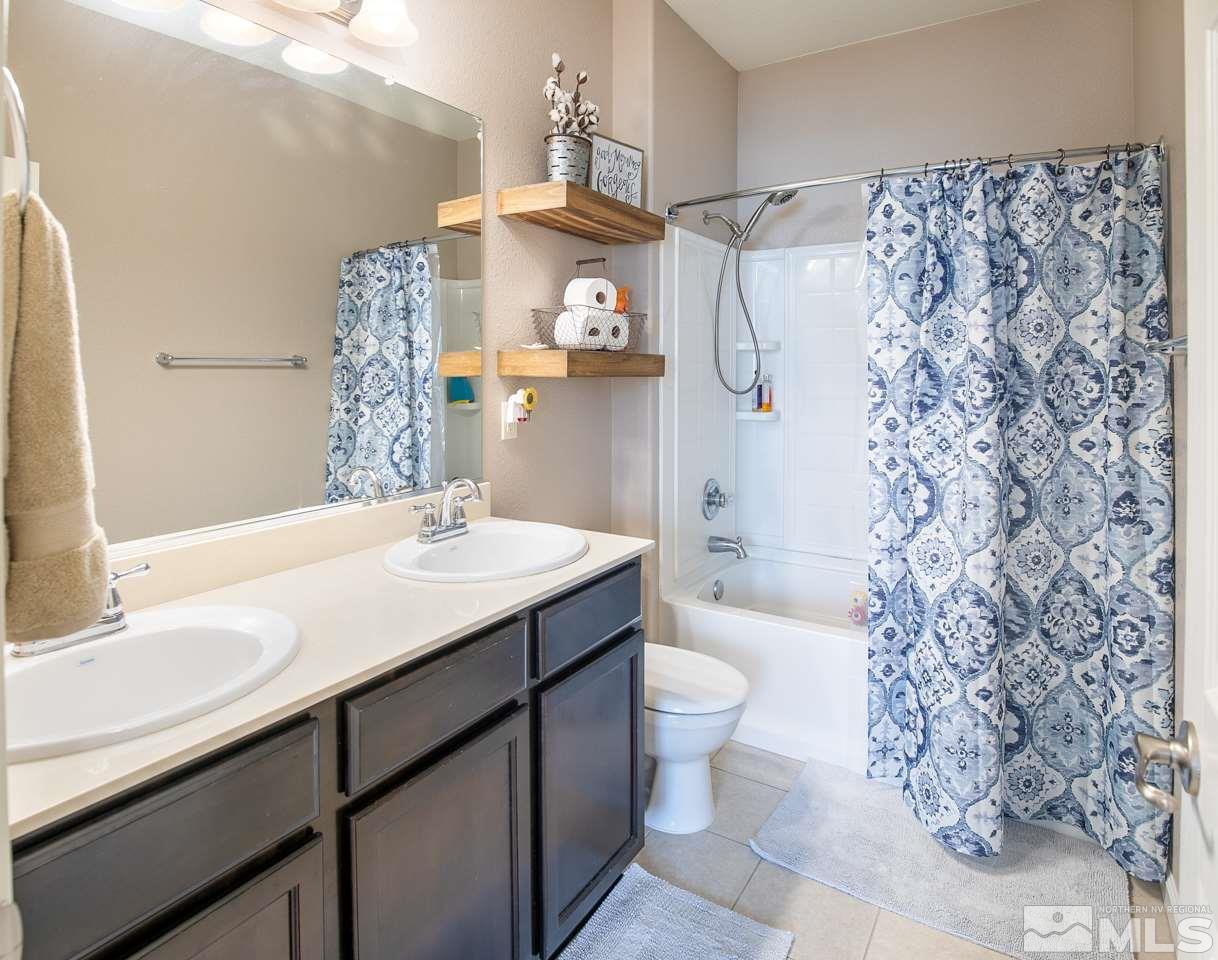 11057 Colton Drive Reno, NV 89521 - Photo 11 of 22 a bathroom with a sink toilet a mirror and shower