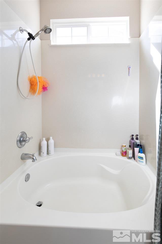 11057 Colton Drive Reno, NV 89521 - Photo 18 of 22 a bathroom with a sink a mirror and a shower