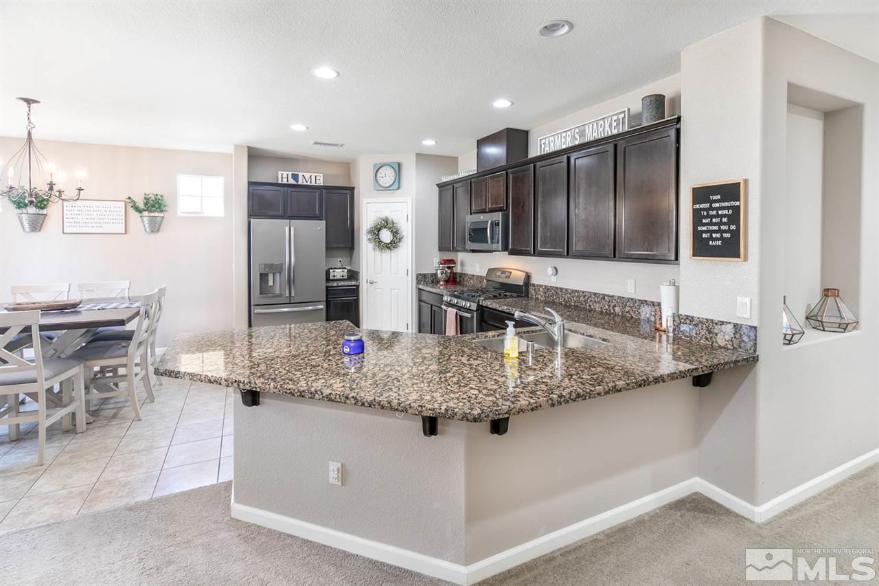 11057 Colton Drive Reno, NV 89521 - Photo 6 of 22 a kitchen with stainless steel appliances granite countertop a sink and a refrigerator