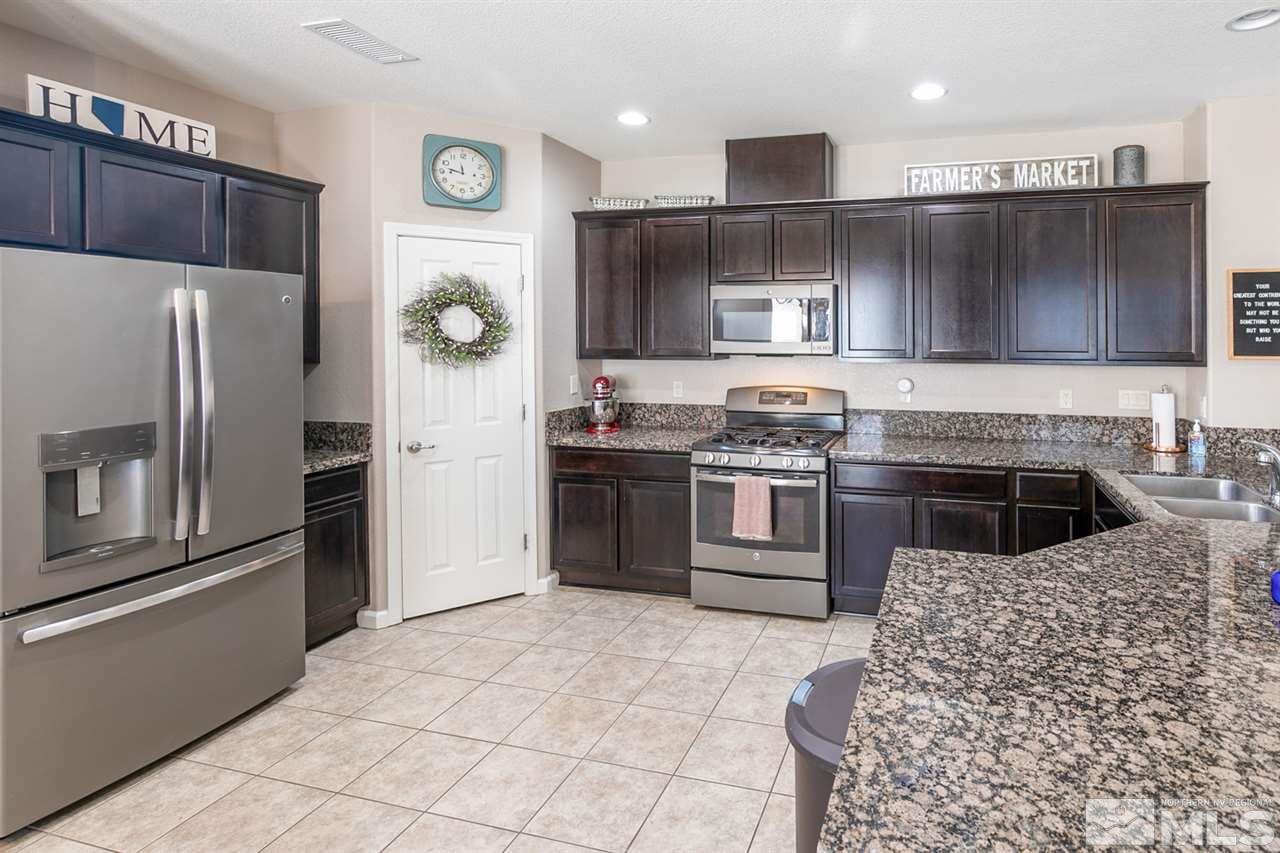 11057 Colton Drive Reno, NV 89521 - Photo 7 of 22 a kitchen with stainless steel appliances granite countertop a refrigerator sink and stove