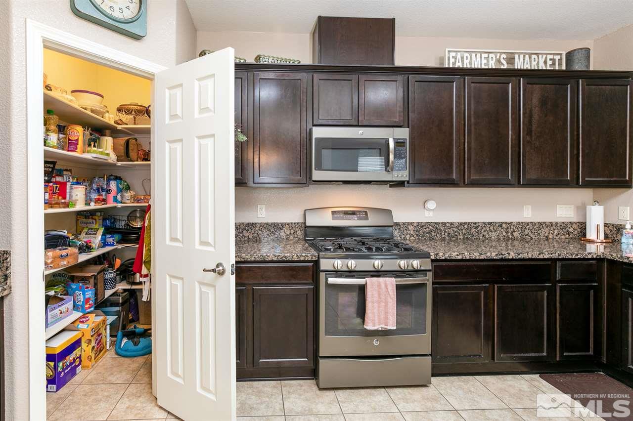 11057 Colton Drive Reno, NV 89521 - Photo 8 of 22 a kitchen with stainless steel appliances granite countertop a stove and a microwave