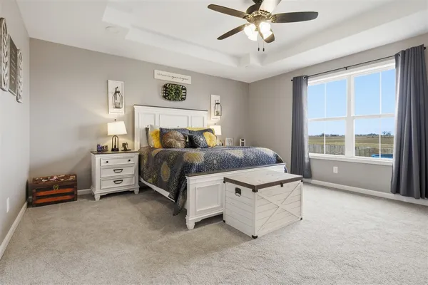 a spacious bedroom with a bed and a chandelier