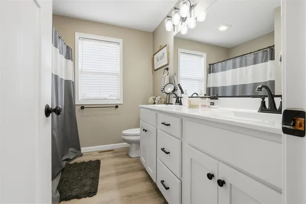 a bathroom with a sink a toilet and a mirror