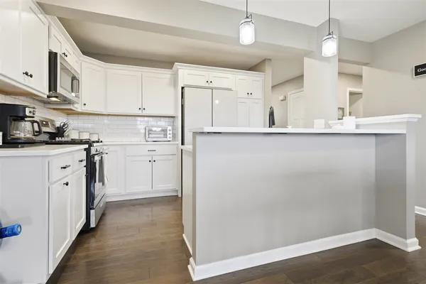 a kitchen with a sink a stove cabinets and wooden floor