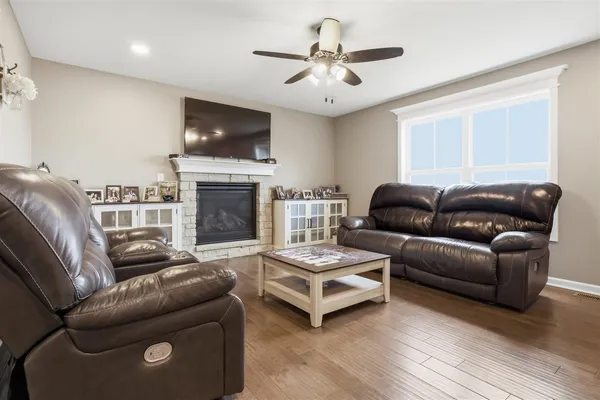 a living room with furniture a flat screen tv and a fireplace