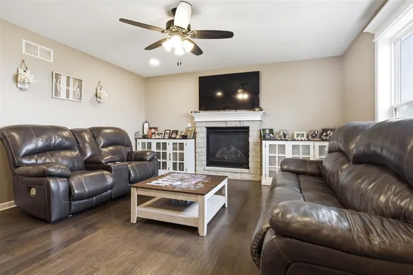 a living room with furniture a flat screen tv and a fireplace