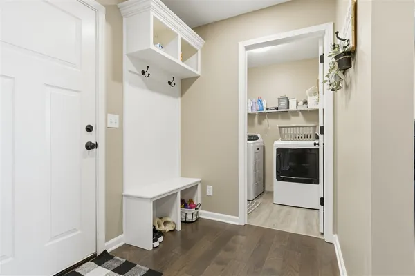a view of a hallway with wooden floor and a cabinet