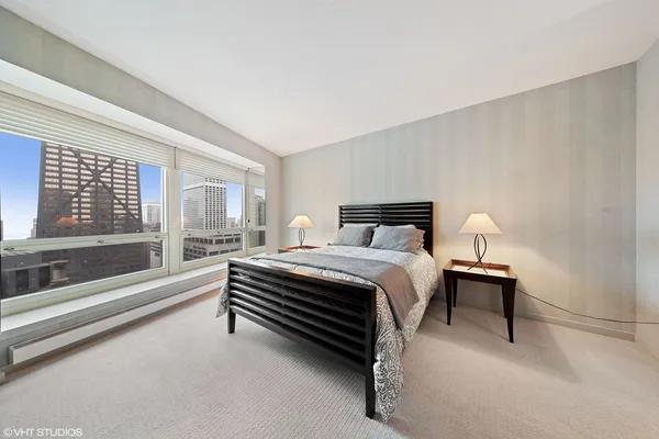 a bedroom with a bed and a large window with outer view