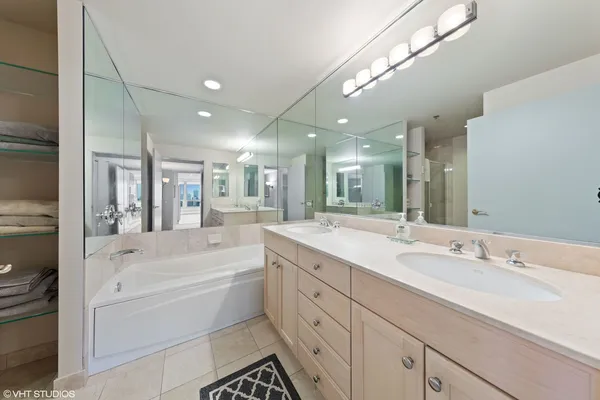 a bathroom with a granite countertop sink mirror bathtub and shower