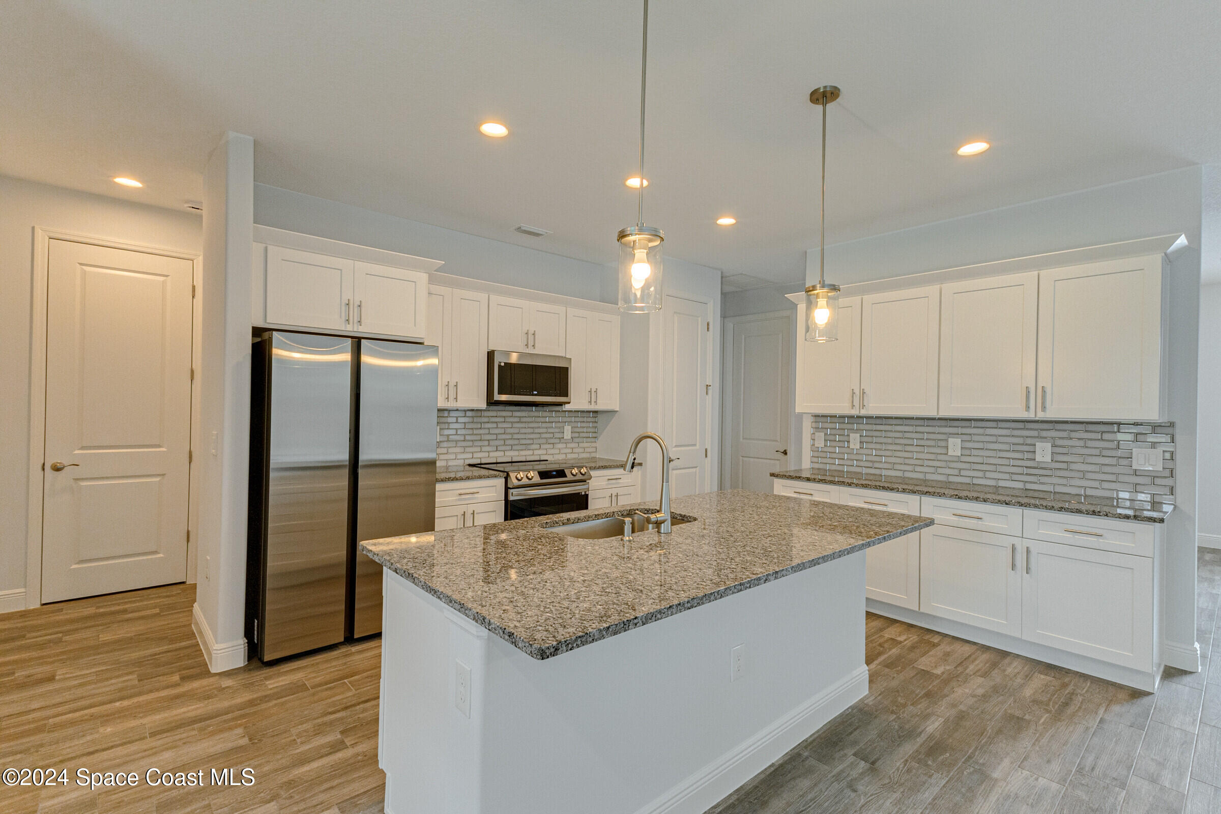 158 Deer Run Road Palm Bay, FL 32909 - Photo 2 of 10 a kitchen with stainless steel appliances granite countertop a sink refrigerator and microwave