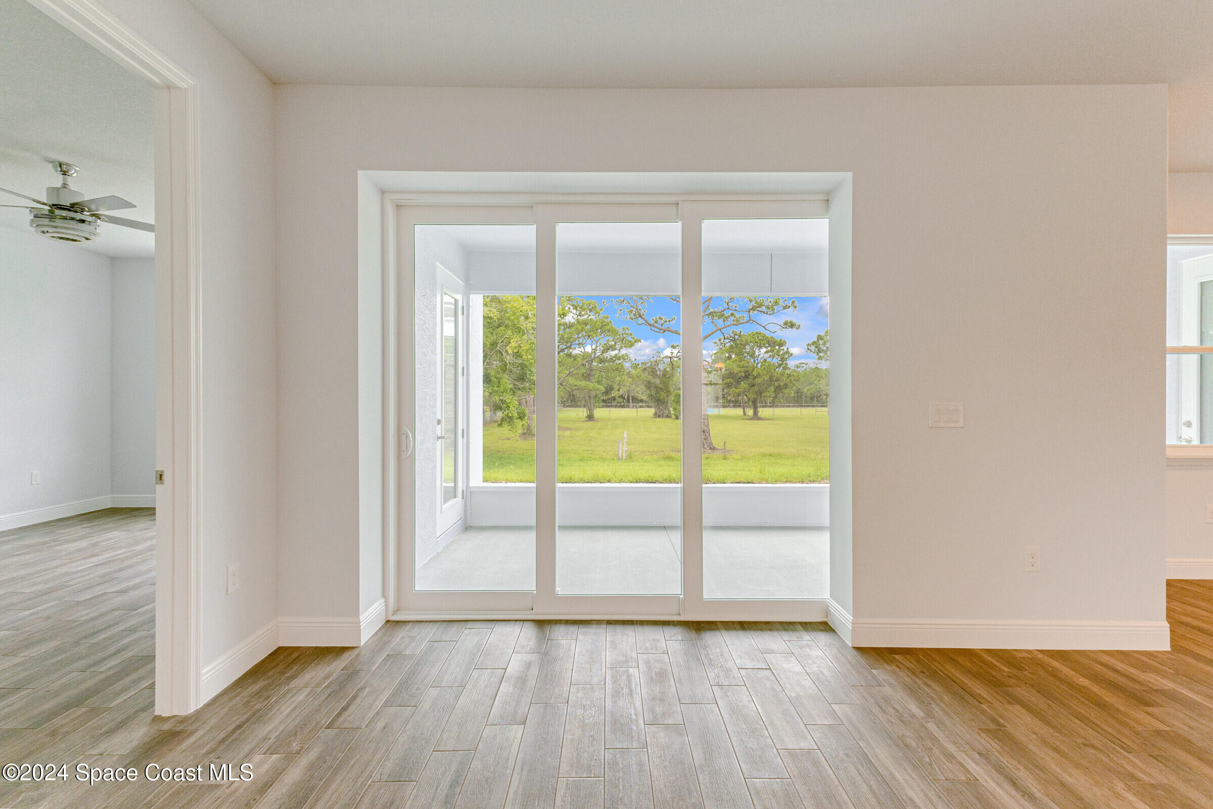 158 Deer Run Road Palm Bay, FL 32909 - Photo 3 of 10 an empty room with wooden floor and windows