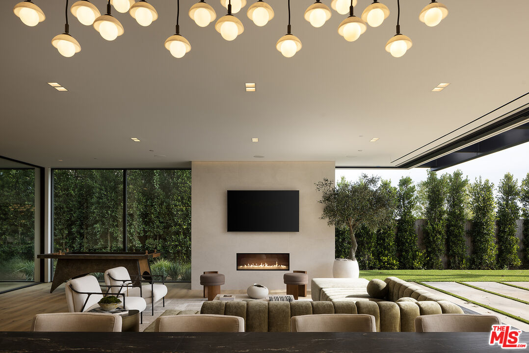 1660 Casale Road Pacific Palisades, CA 90272 - Photo 27 of 44 a living room with furniture a flat screen tv and a large window