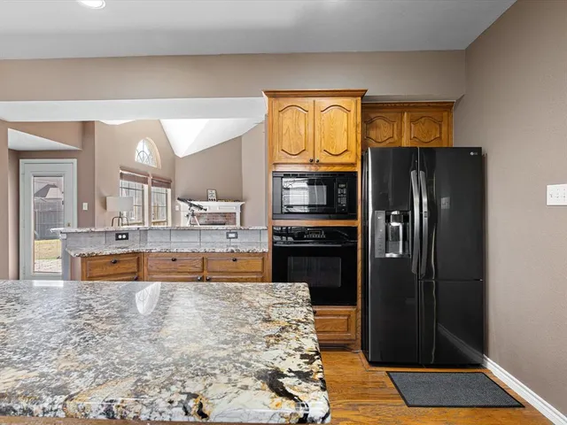 a kitchen with stainless steel appliances granite countertop a refrigerator and a sink