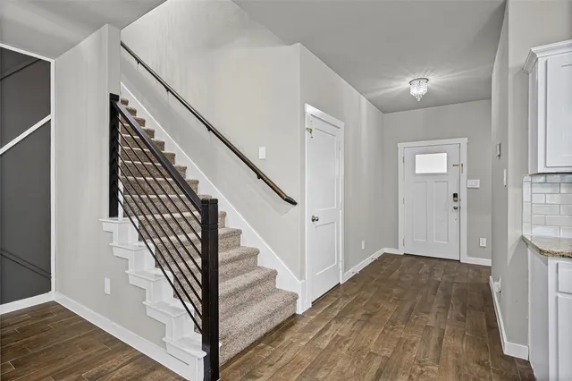 a view of a hallway with wooden floor and entryway