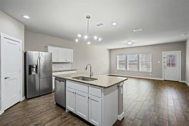 a kitchen that has a lot of counter space and wooden floor