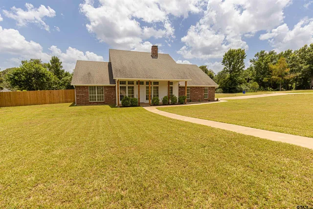 a view of a large pool with lawn chairs and large trees