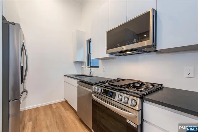 a kitchen with stainless steel appliances a sink and a microwave