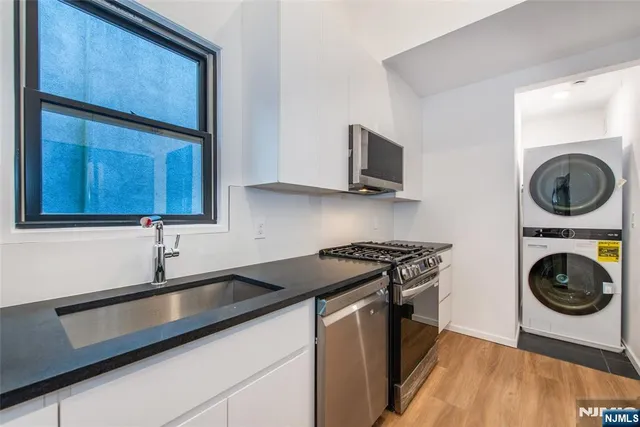 a kitchen with a sink a stove and cabinets