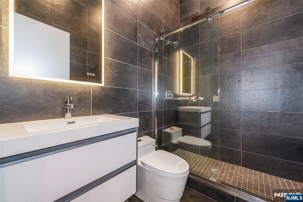 206 Harrison Avenue, Unit 1 Harrison, NJ 07029 - Photo 5 of 10 a bathroom with a sink toilet and shower