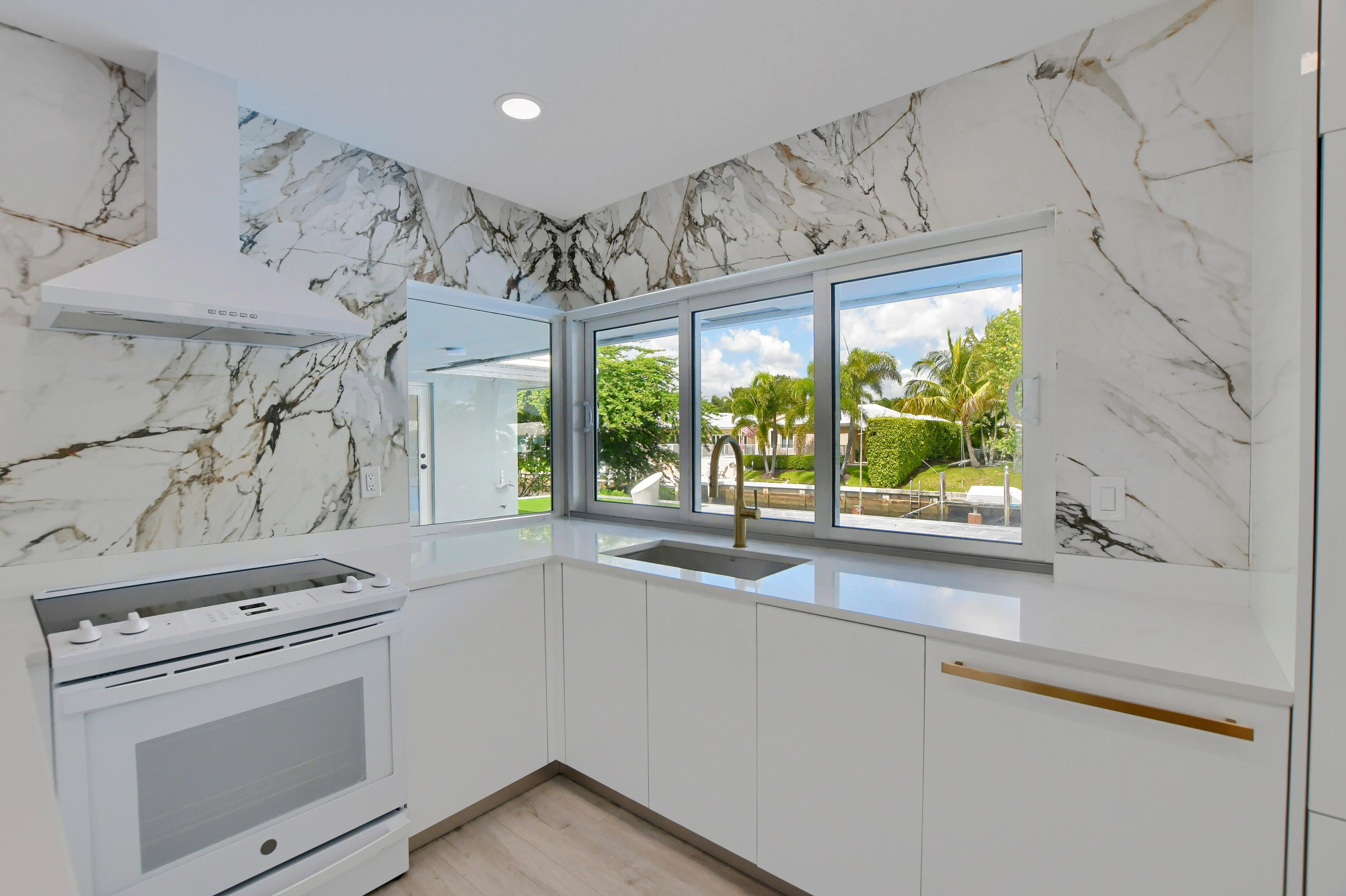 891 Hickory Terrace Boca Raton, FL 33486 - Photo 12 of 56 a kitchen with a stove a sink and a microwave
