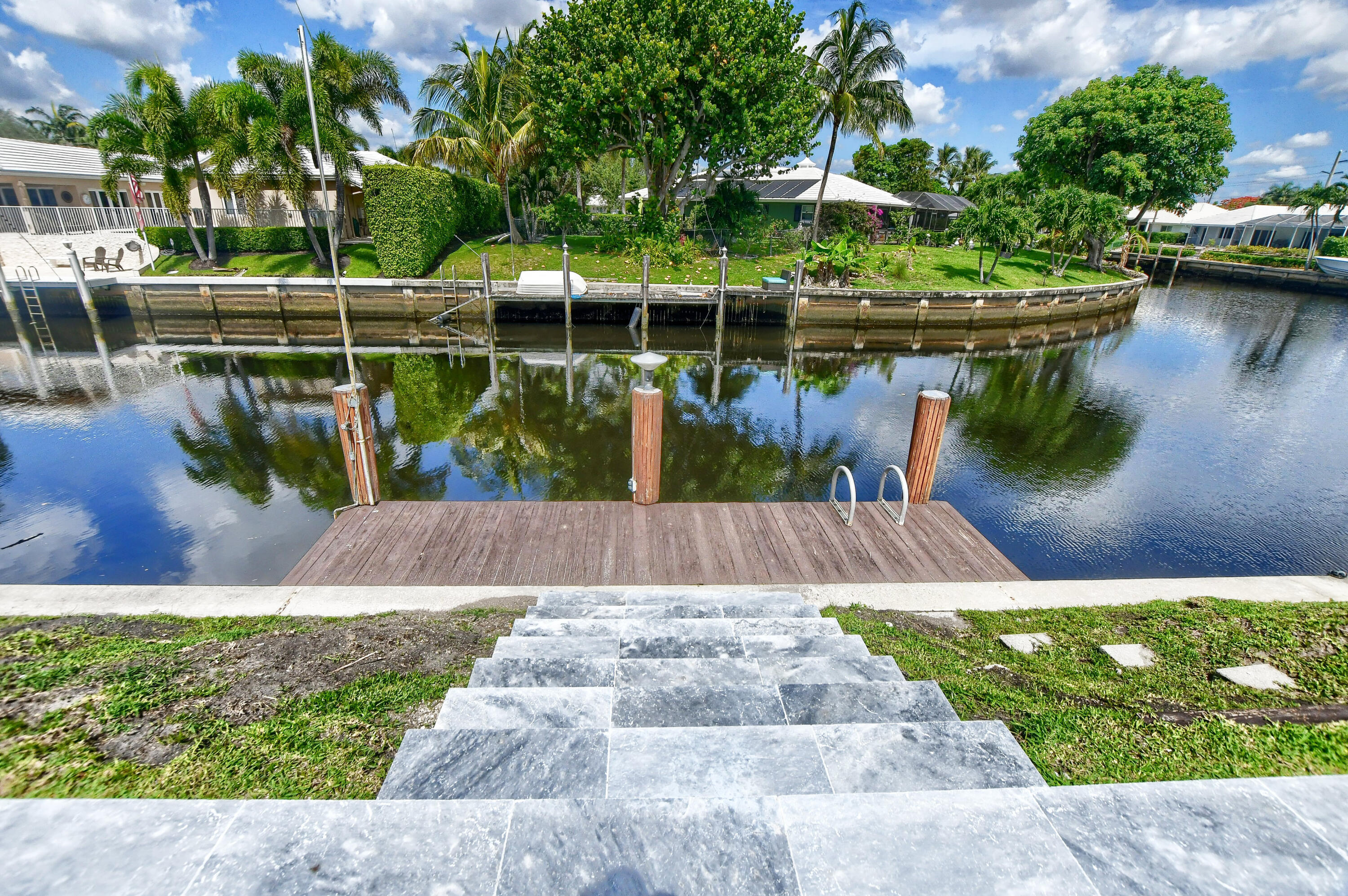 891 Hickory Terrace Boca Raton, FL 33486 - Photo 51 of 56 a view of a lake with a bench next to a lake