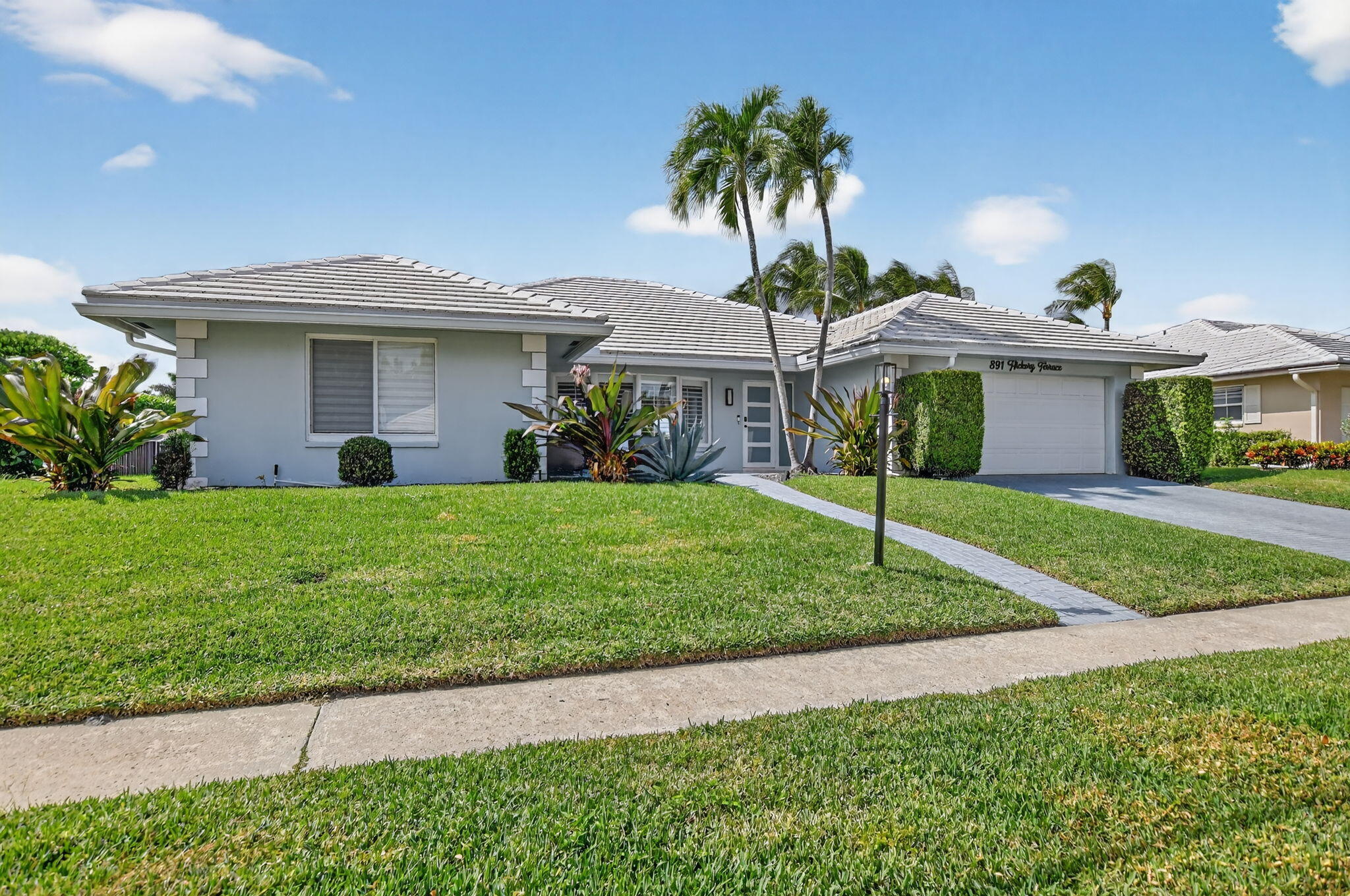 891 Hickory Terrace Boca Raton, FL 33486 - Photo 56 of 56 a front view of a house with a yard and palm trees