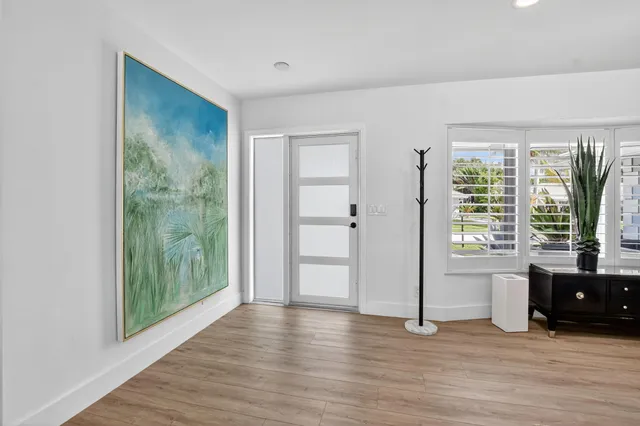 a kitchen with stainless steel appliances granite countertop a kitchen island hardwood floor and a sink