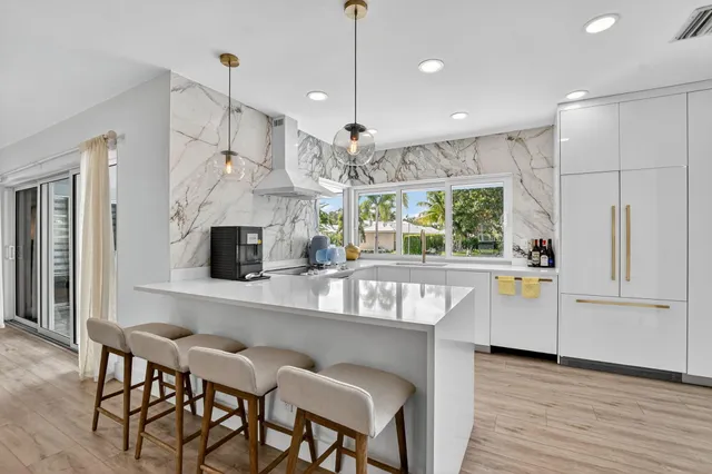 a kitchen with stainless steel appliances granite countertop a refrigerator and a stove top oven