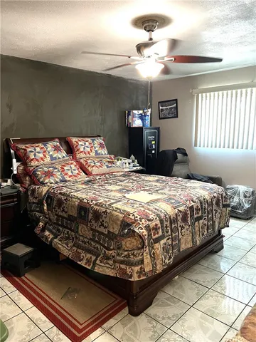 a large bed sitting in a bedroom next to a window and a chandelier