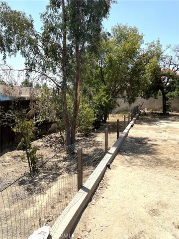a view of a yard with wooden fence