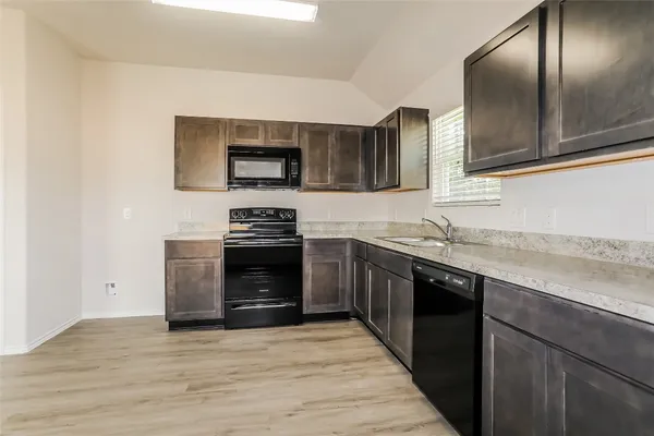 a kitchen with stainless steel appliances granite countertop a stove a sink and a microwave