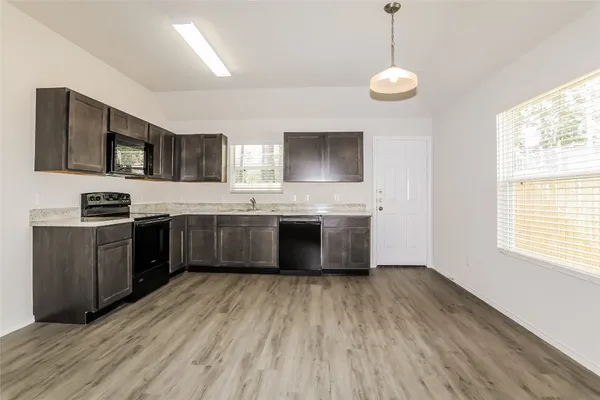 a kitchen with stainless steel appliances granite countertop a sink counter space cabinets and a large window