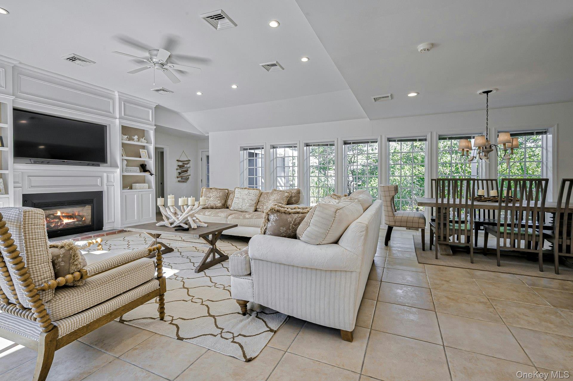 39 Sloop Walk Ocean Beach, NY 11770 - Photo 20 of 46 Open concept living space featuring a built-in media center with fireplace, recessed lighting, a ceiling fan, and light-toned tile flooring