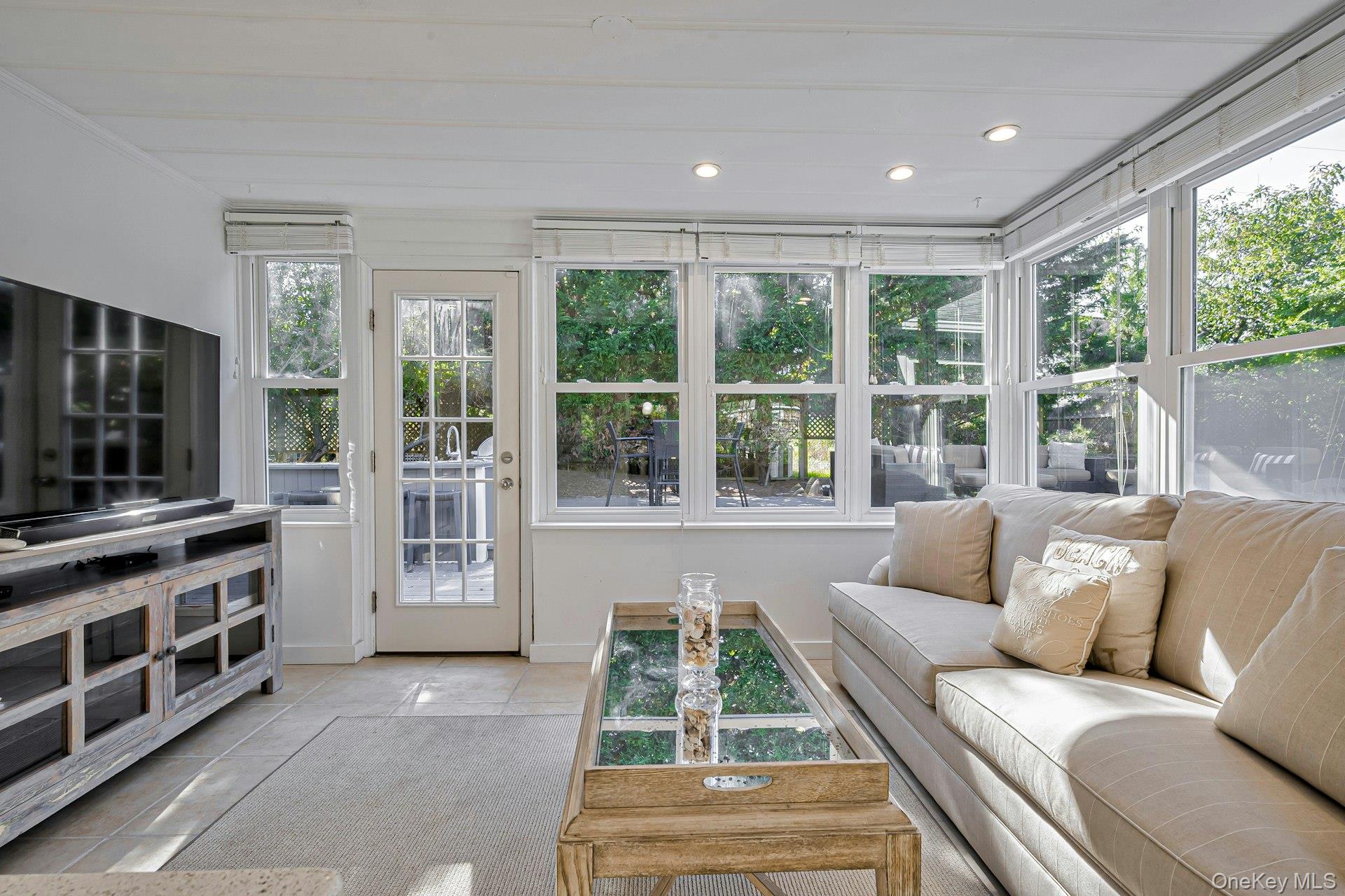 39 Sloop Walk Ocean Beach, NY 11770 - Photo 23 of 46 Sun-filled room featuring extensive windows, a glass-paned door, recessed lighting, white wood-plank ceiling, and light-toned tile flooring