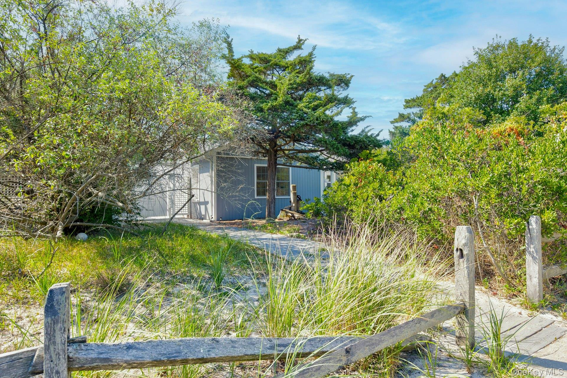 39 Sloop Walk Ocean Beach, NY 11770 - Photo 5 of 46 Wood pathway leading to a residence with light blue siding, white trim