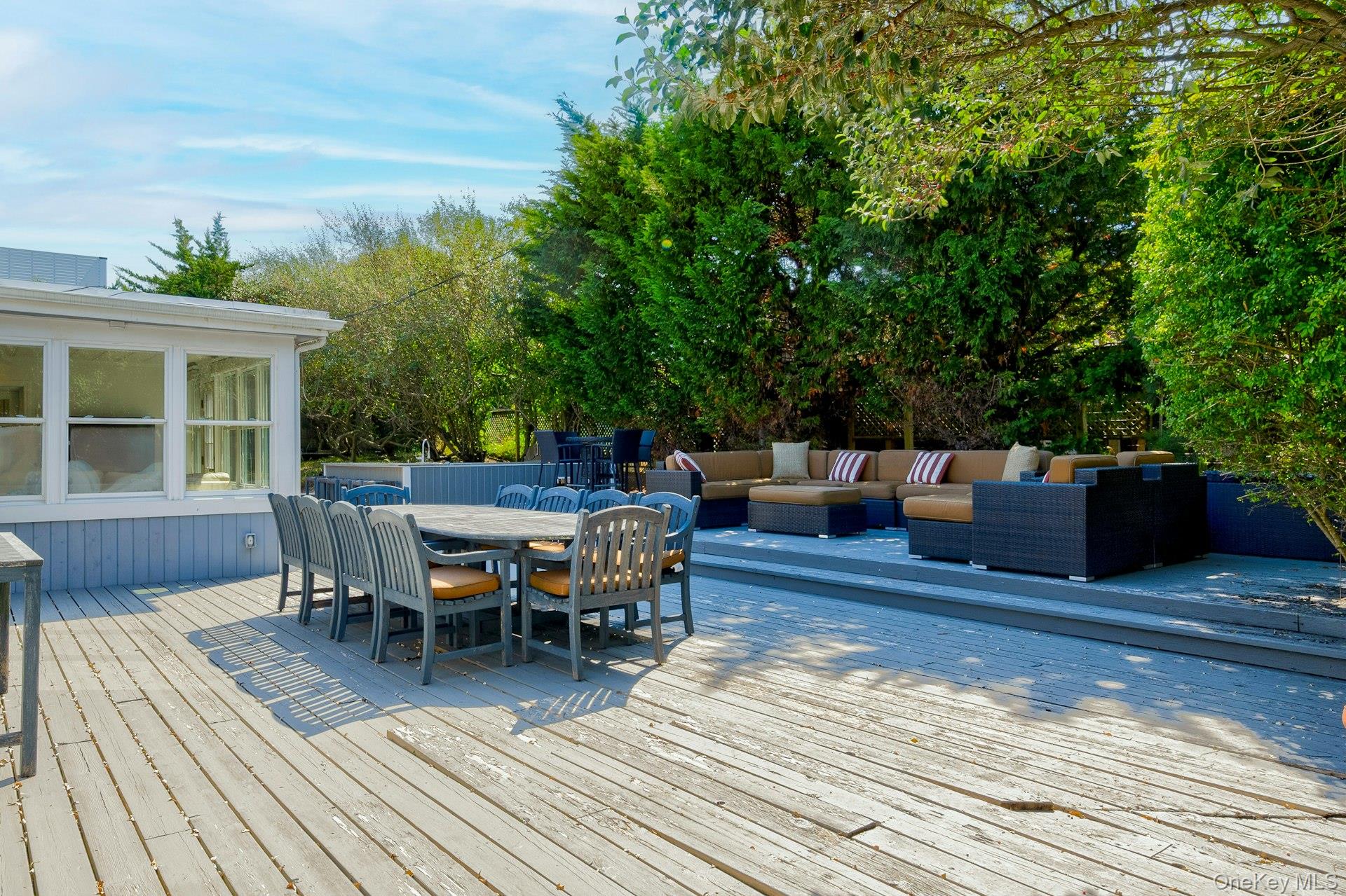 39 Sloop Walk Ocean Beach, NY 11770 - Photo 6 of 46 Multi-level wood deck featuring a dining area, a defined lounge space, and mature perimeter landscaping