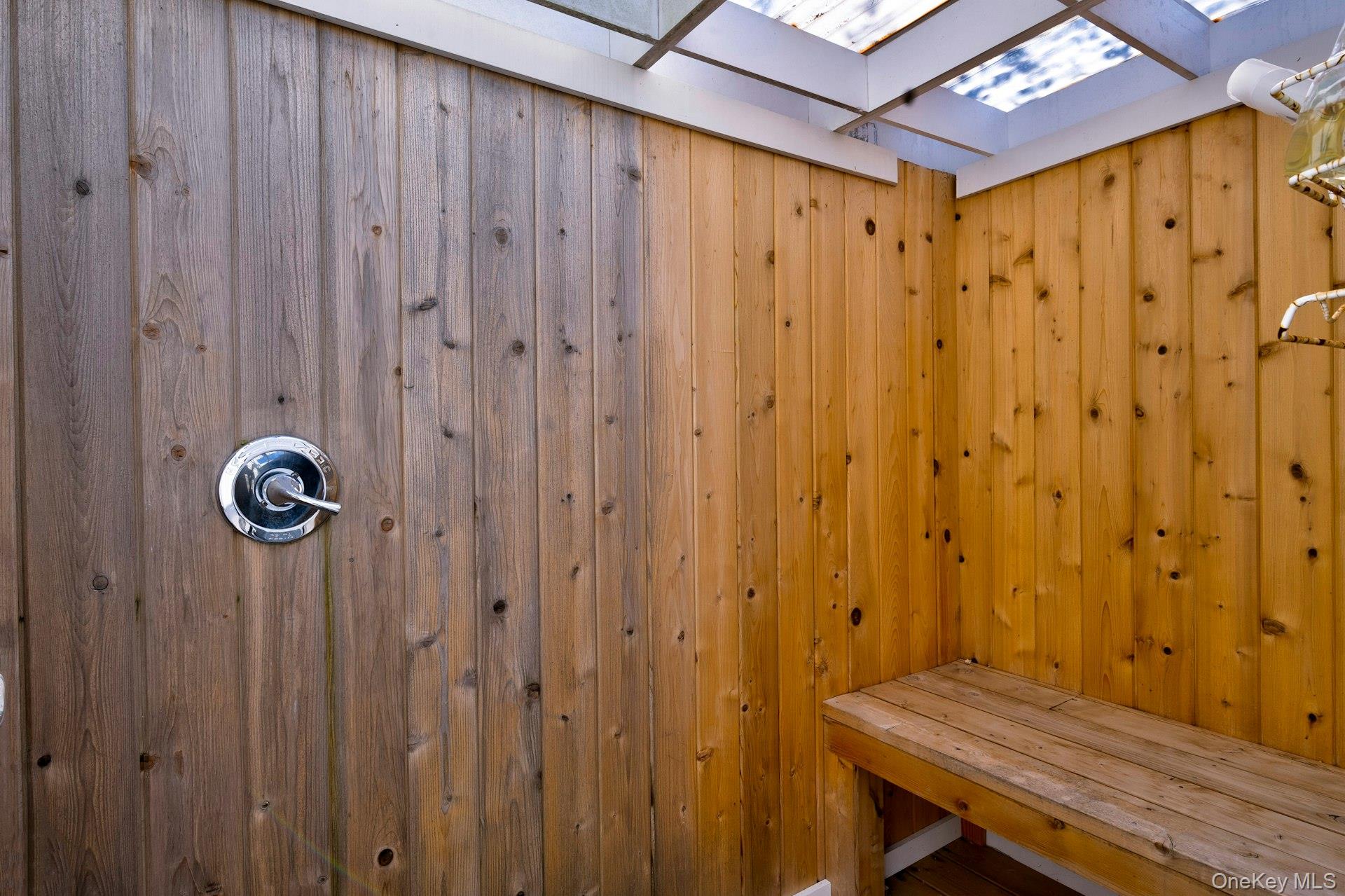 39 Sloop Walk Ocean Beach, NY 11770 - Photo 8 of 46 Wood-paneled outdoor shower featuring a built-in wooden bench and a chrome shower fixture